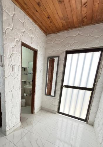 a white room with a window and a bathroom at Boutique Playa DanRay in La Perdiz