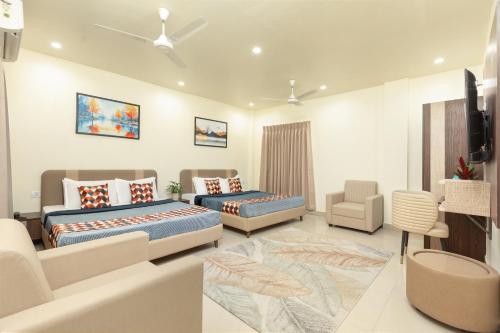 a bedroom with two beds and a couch at Greens Venue in Chennai