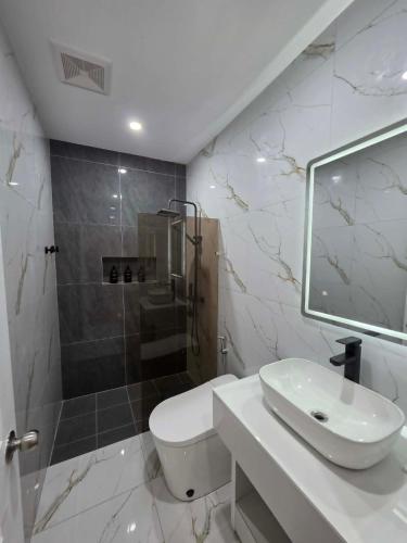 a white bathroom with a sink and a shower at MSResort Panglao in Looc