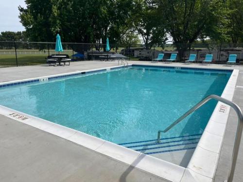 a large swimming pool with blue chairs and tables at Grand Park Spa Getaway in Westfield