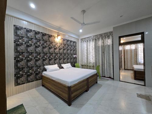 a bedroom with a bed and a brick wall at SHREE RAMA Niwasam in Ayodhya
