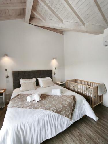 a bedroom with a large bed with white walls at Monte do Sol in São Luis