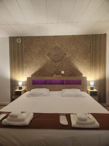 a bedroom with a large bed with towels on it at Le Cocon Du Lac in Nantua