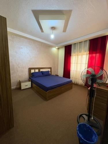 a bedroom with a bed and a fan in it at الوليد للشقق المفروشة in Amman