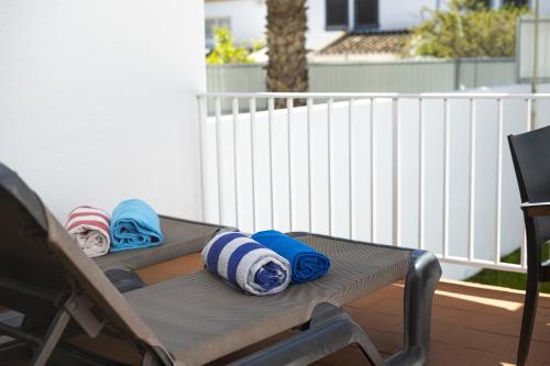 a patio table with blankets and pillows on it at Mouraliz Apartments by HD PROPERTIES - Vilamoura Marina in Vilamoura