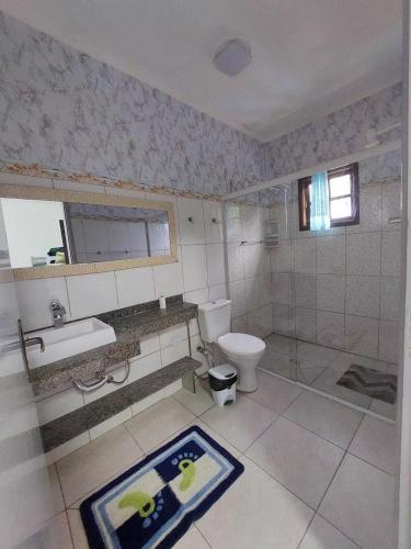 a bathroom with a toilet and a sink and a mirror at Pousada Nascimentos -Pé na Areia- À 47 Passos do Mar in Bertioga