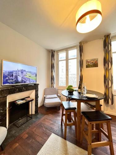 a living room with a table and a fireplace at T2 Amboise avec vue sur le Château Royal in Amboise