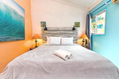 a bedroom with a large bed with two towels on it at Beachfront Two-Bedroom Villa in Savaneta