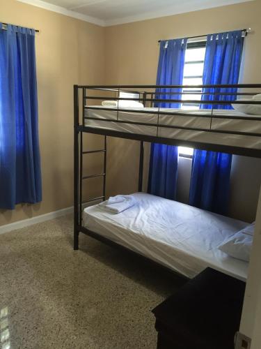 two bunk beds in a room with blue curtains at Arecibo Inn in Arecibo