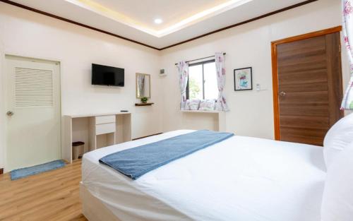 a bedroom with a large white bed and a desk at villa Tip in Ban Na An