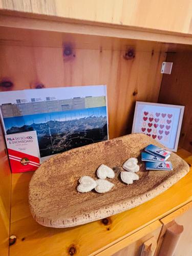 a shelf with three cookies on top of a table at Edelweiss Pila-Ski appartment con vista montagne in Pila