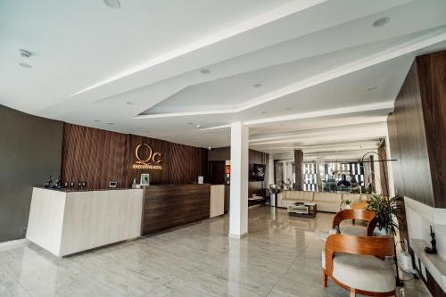 a lobby with a reception desk and chairs at Hotel QC in Trujillo