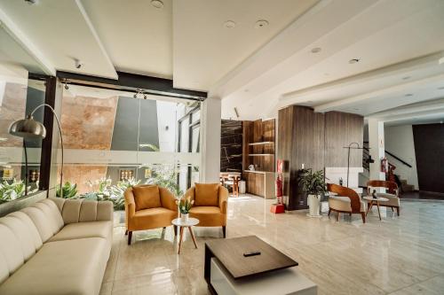 a large living room with a couch and chairs at Hotel QC in Trujillo