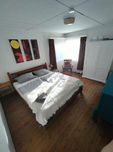 a bedroom with a large bed with a wooden floor at Ferienhaus Tätendorf für die ganze Familie in Tätendorf-Eppensen