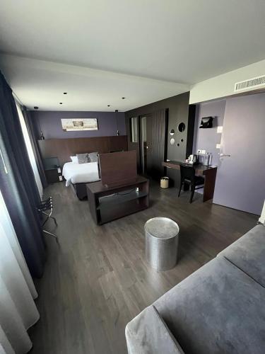 a hotel room with a bed and a desk at Hotel le Broceliande - Sure Hotel Collection by Best Western in Bédée