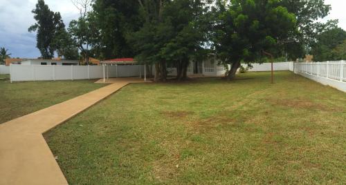 a large yard with a white fence and trees at Arecibo Inn in Arecibo