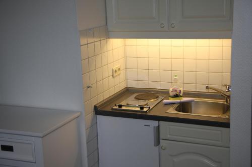 a kitchen with a sink and a counter top at Apartmenthaus Witthüs in Wenningstedt