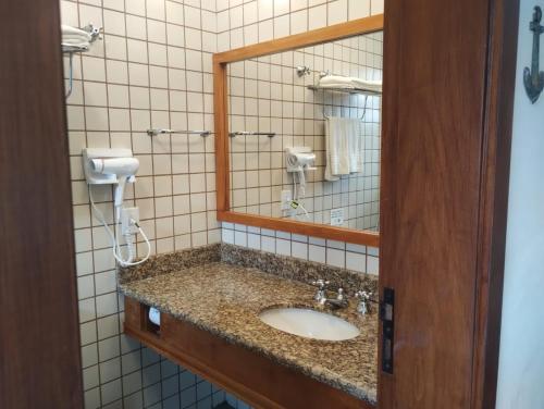 a bathroom with a sink and a mirror at Beira mar Flat 2-209 in Ilhabela
