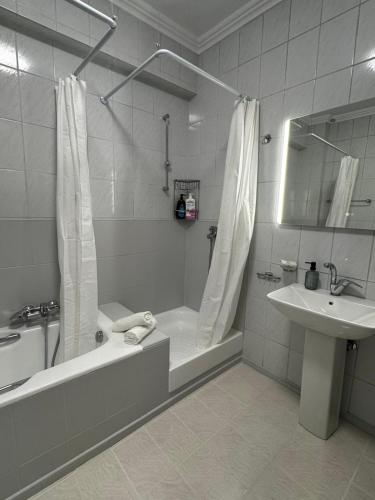 a bathroom with a tub shower and a sink at Animus House #1 Apartment, Peraia in Perea