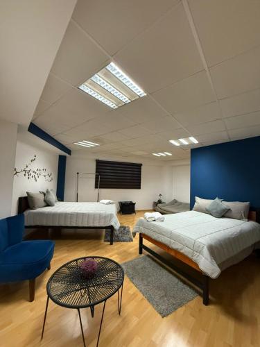 a bedroom with two beds and a blue wall at Tiny Rooms in Toluca