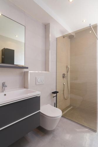 a bathroom with a shower and a toilet and a sink at Mare Vista Rooftop Penthouse Sea View & Private Jacuzzi in Trogir