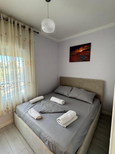 a bedroom with a bed with two towels on it at Arli's SeaFront Apartaments in Durrës