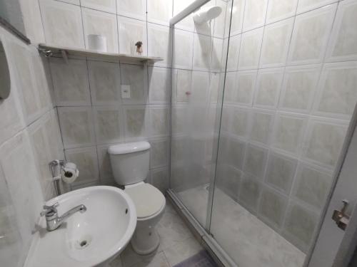 a bathroom with a shower and a toilet and a sink at Solares Aconchego - Suíte in Búzios