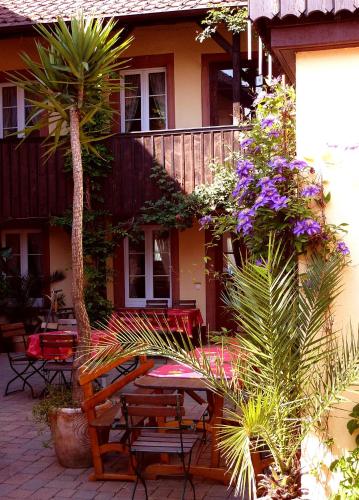 a patio with a bench and a balcony with flowers at Historisches Genusshotel Löwen in Schopfheim