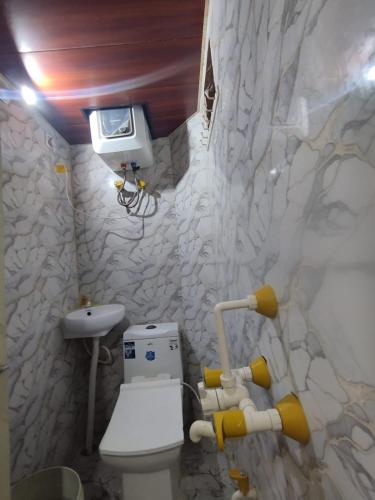 a bathroom with a toilet and a stone wall at Nishad Raj bhawan in Vrindāvan