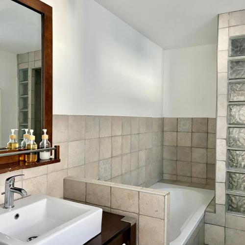 a bathroom with a sink and a bath tub at le chemin des pouzes in Vallon-Pont-dʼArc