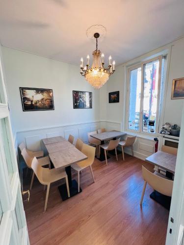 a dining room with tables and chairs and a chandelier at Hôtel De La Cathédrale in Reims