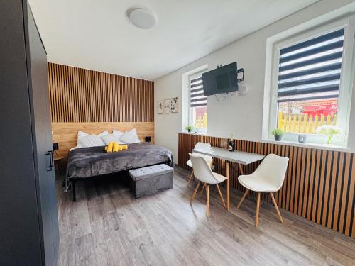 a bedroom with a bed and a table and chairs at Too Apartment Lipno in Černá v Pošumaví