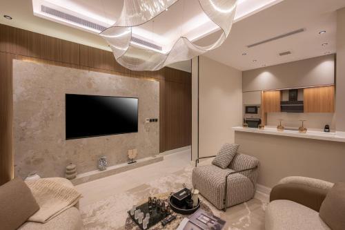 a living room with a tv and a couch and chair at Rozn Place Apartments in Jeddah