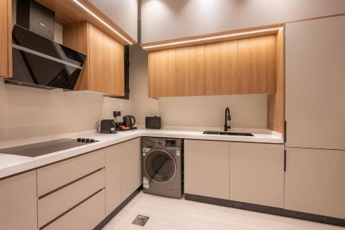 a kitchen with white cabinets and a washing machine at Rozn Place Apartments in Jeddah