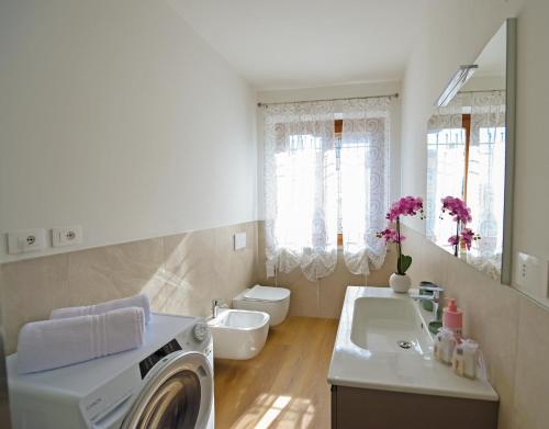 a bathroom with a washing machine and a sink at Affittacamere Marilù in Paratico