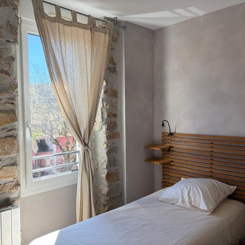 a bedroom with a bed and a window at le chemin des pouzes in Vallon-Pont-dʼArc