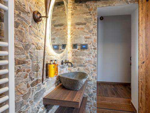 a stone bathroom with a stone sink and a mirror at Cjase Friûl in Cividale del Friuli