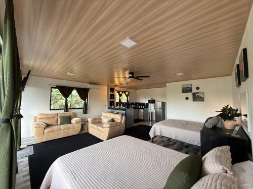 a bedroom with two beds and a living room at Arenal cautiva in El Castillo de La Fortuna