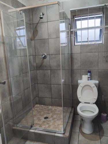 a bathroom with a shower with a toilet at Sun & Night in Empangeni