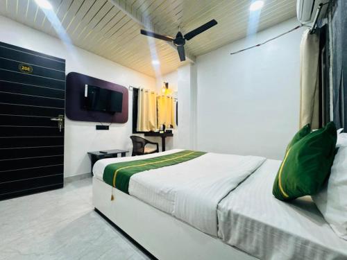 a bedroom with a bed and a tv in it at Hotel Green Valley in Raipur