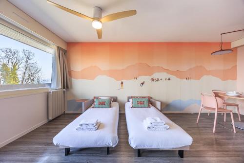 a childrens room with two beds and a table at Côté Lac Hostel Evian in Évian-les-Bains