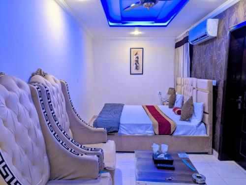 a bedroom with a bed and a couch and a table at Royal Fort Executive Hotel Gulberg in Lahore
