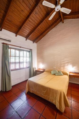 a bedroom with a bed and a ceiling fan at Green House in Villa General Belgrano