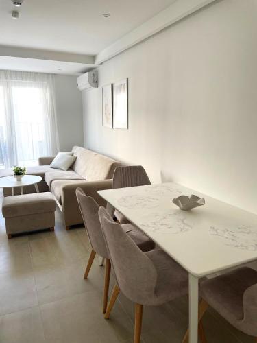 a living room with a table and a couch at Apartmani Villa Antea in Klek