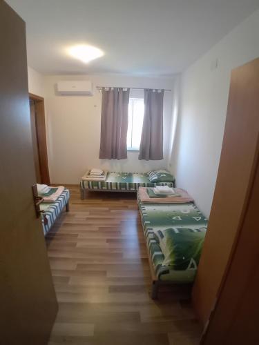 ein Zimmer mit drei Betten und einem Fenster in der Unterkunft Sobe Soldo in Međugorje