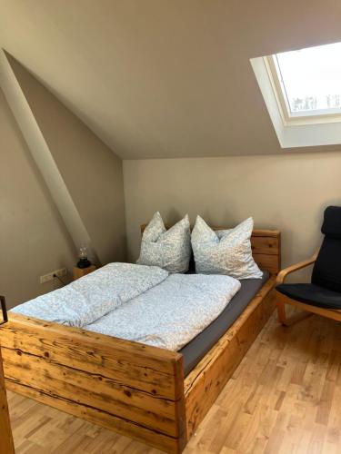 a bedroom with a wooden bed with pillows at Alte Gärtnerei in Blankenburg