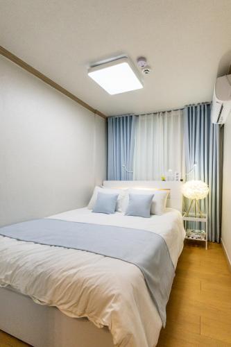 a bedroom with a large bed with blue pillows at 홍대 골든스테이 in Seoul