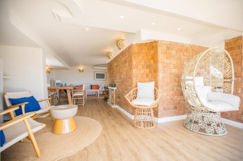 a living room with chairs and a brick wall at The Salty Lodge in Lagos
