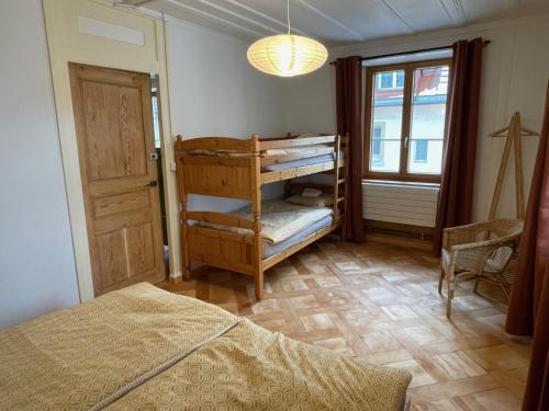 a bedroom with a bed and a room with a window at Maison La Coquille in La Chaux-de-Fonds