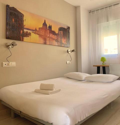 a bedroom with a bed with two lamps on it at Ático dúplex - 1ª Linea playa in Adra
